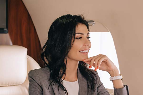 smiling businesswoman sitting in first class on a plane