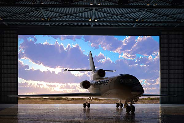 airplane in a hanger against a blue cloudy sky